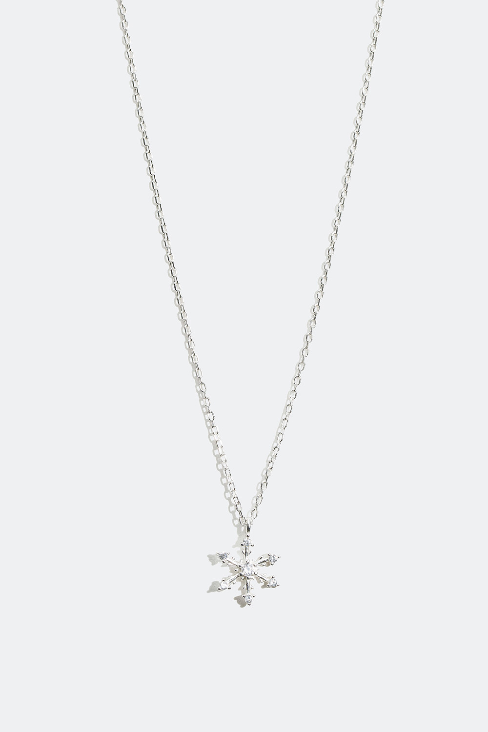 Aito hopeakaulakoru, jossa lumihiutale ja kiviä