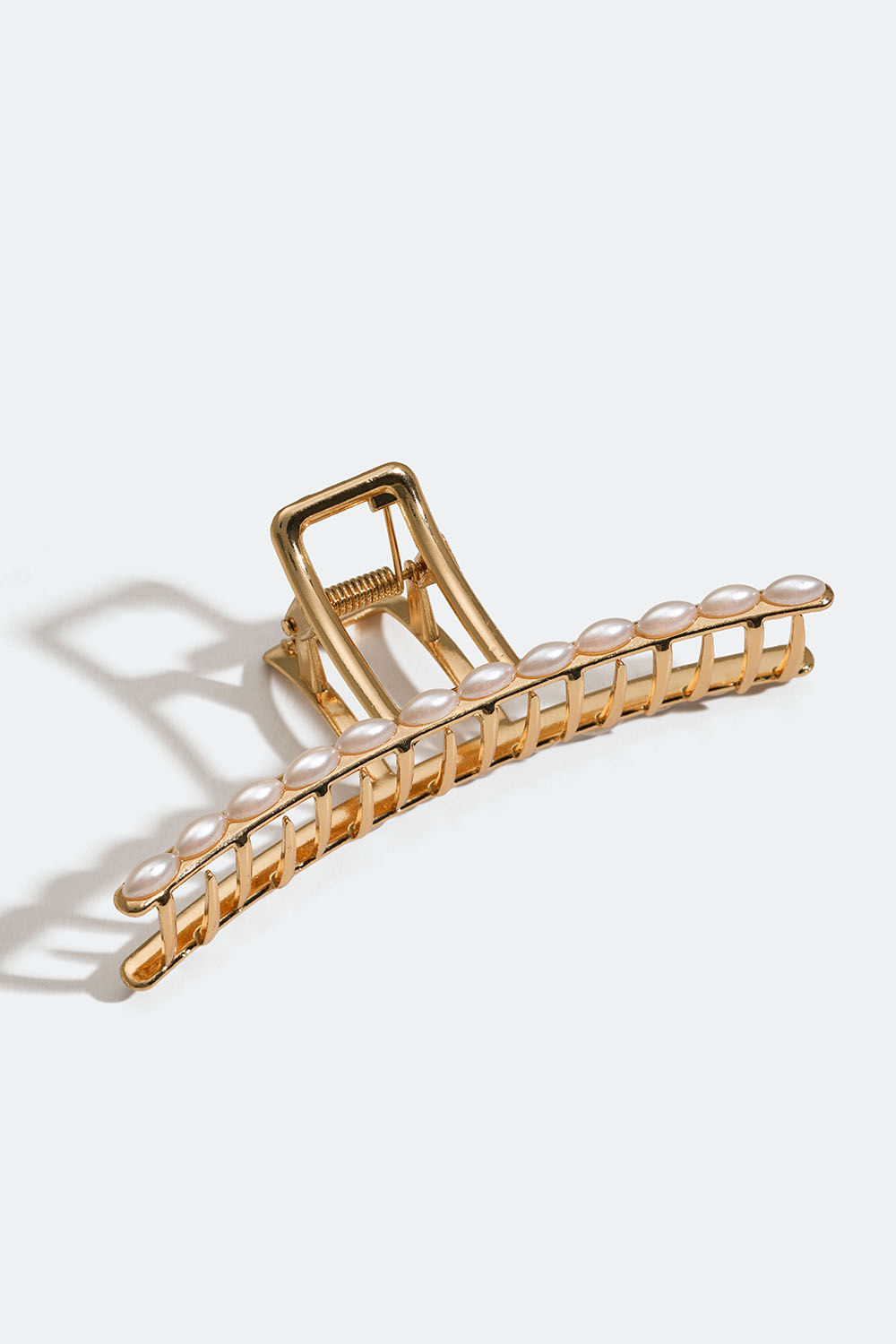 Kullanvärinen hiusklipsi, jossa valkoisia helmiä