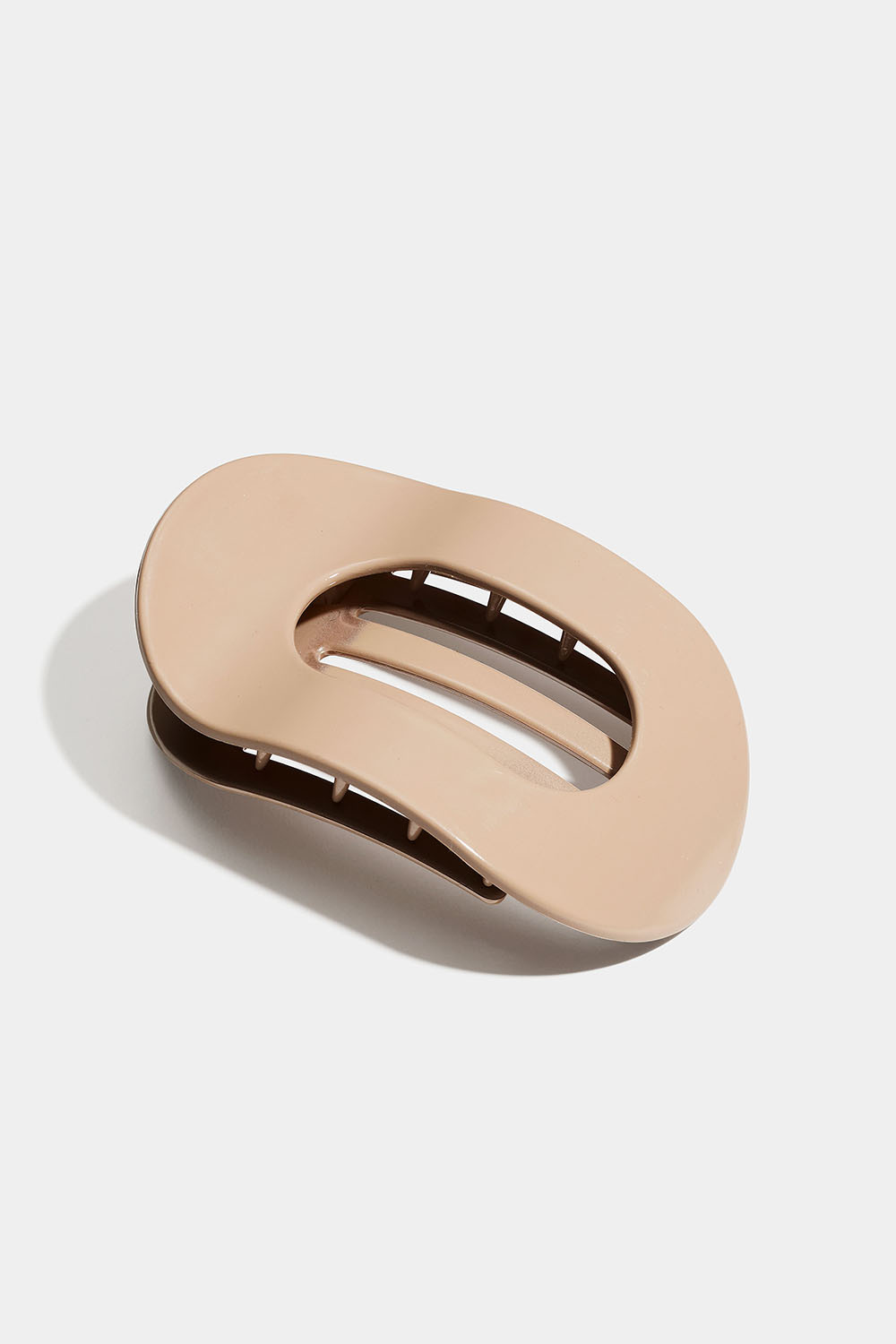 Soikea ja litteä beigenvärinen hiusklipsi