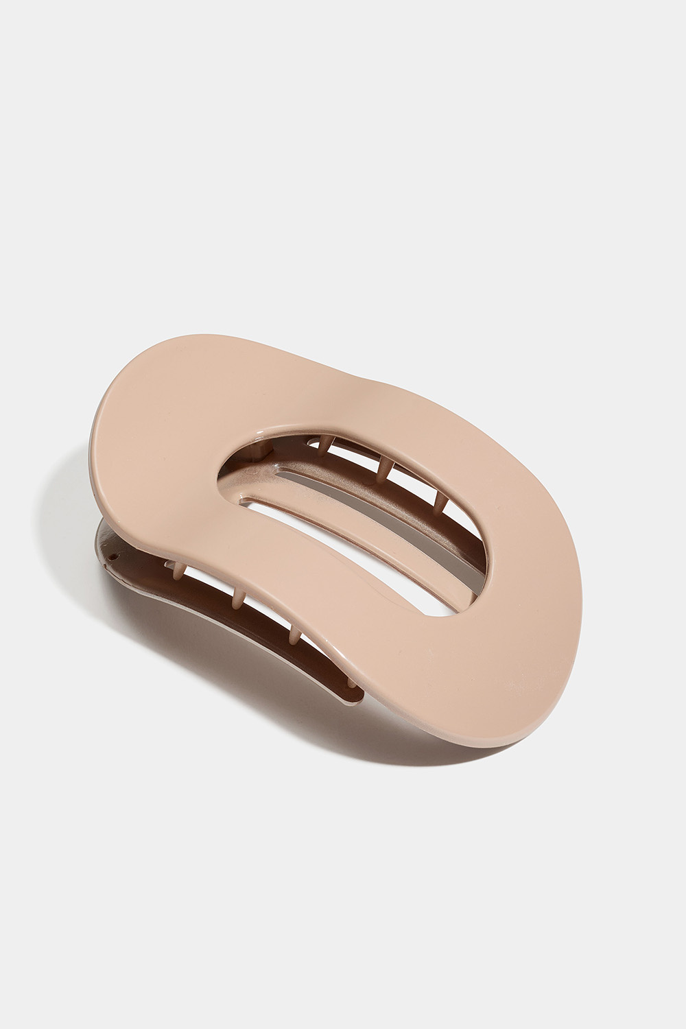 Soikea ja litteä beigenvärinen hiusklipsi