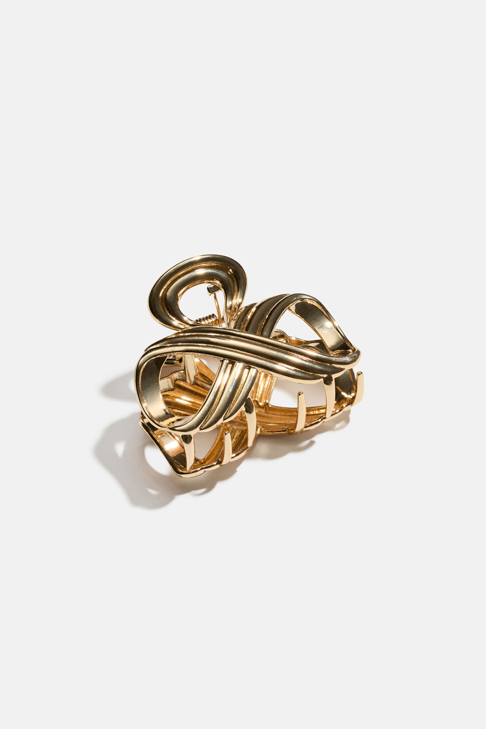 Kullanvärinen metallihiussklipsi, jossa on pyöreät muodot