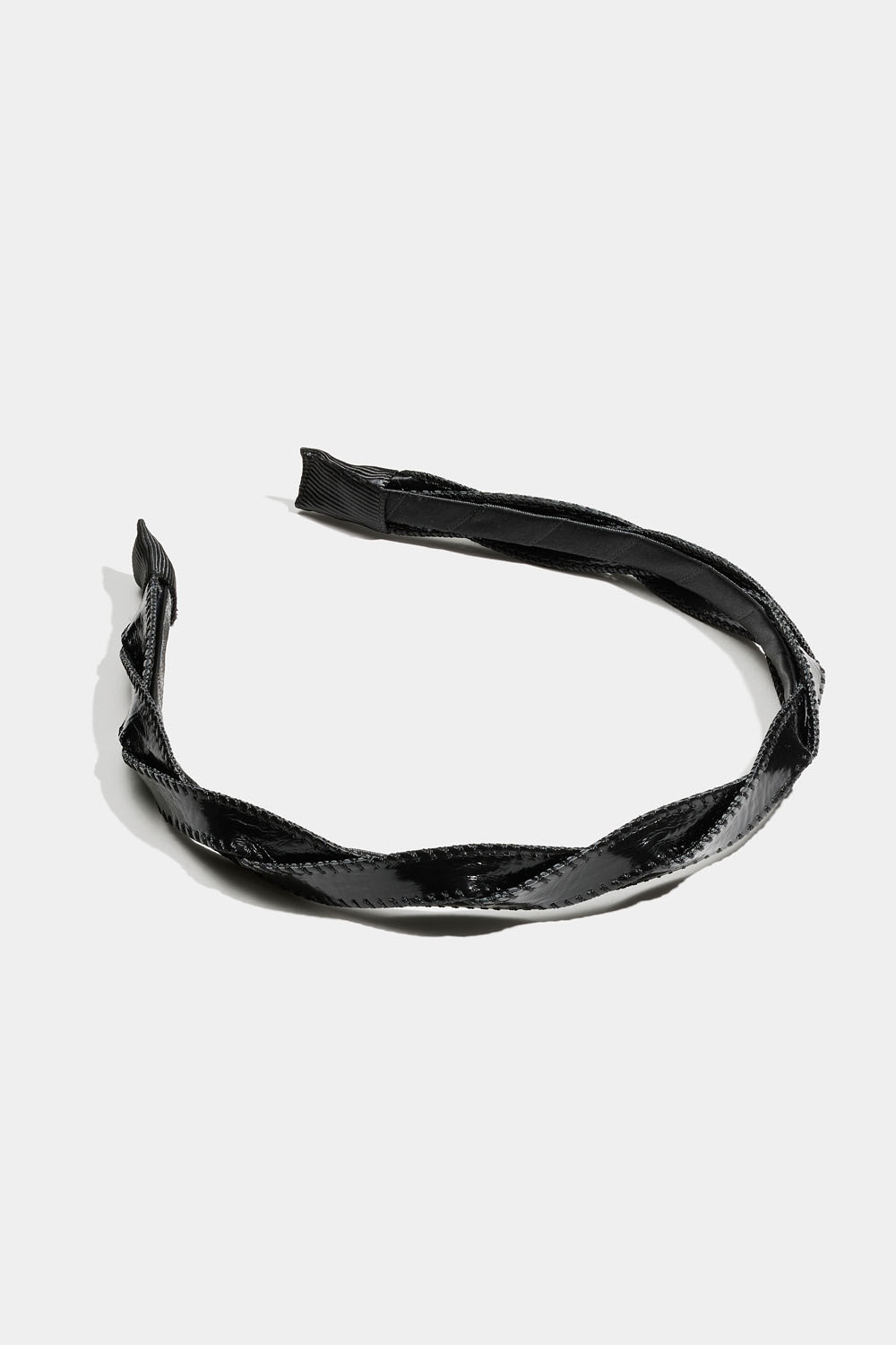 Musta hiuspanta kierretyllä nauhalla