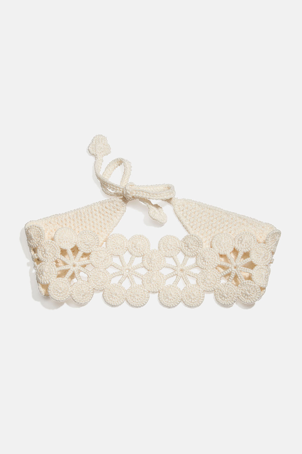 Valkoinen virkattu hiuspanta, jossa kukkakuvioita