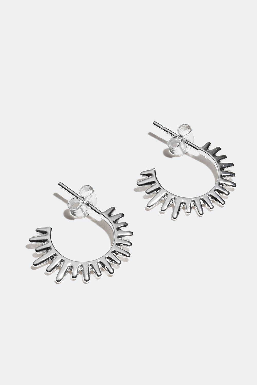 Aidot hopeiset korvarenkaat, joissa niittejä