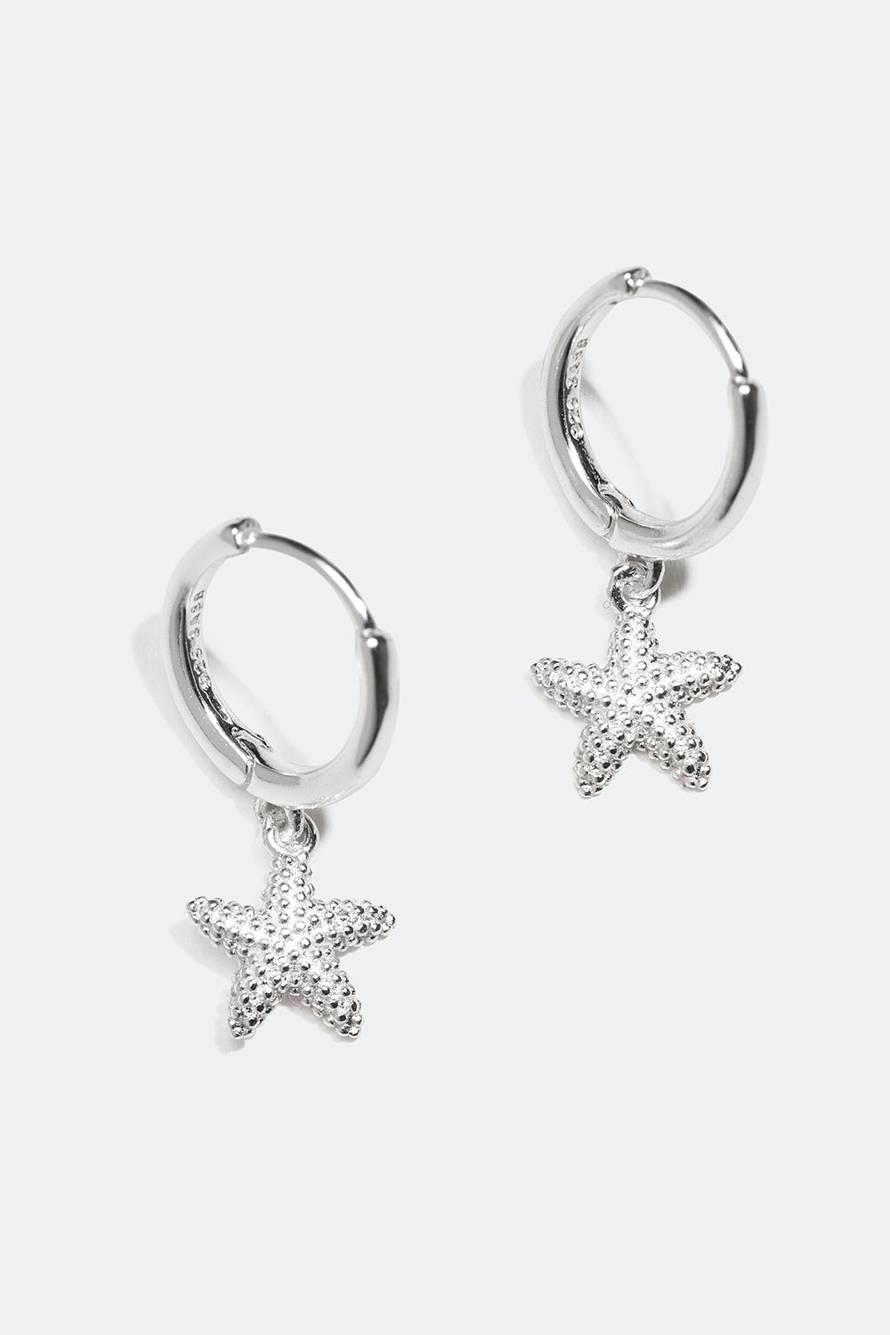 Aidosta hopeasta valmistetut korvarenkaat, joissa meritähtiaihe