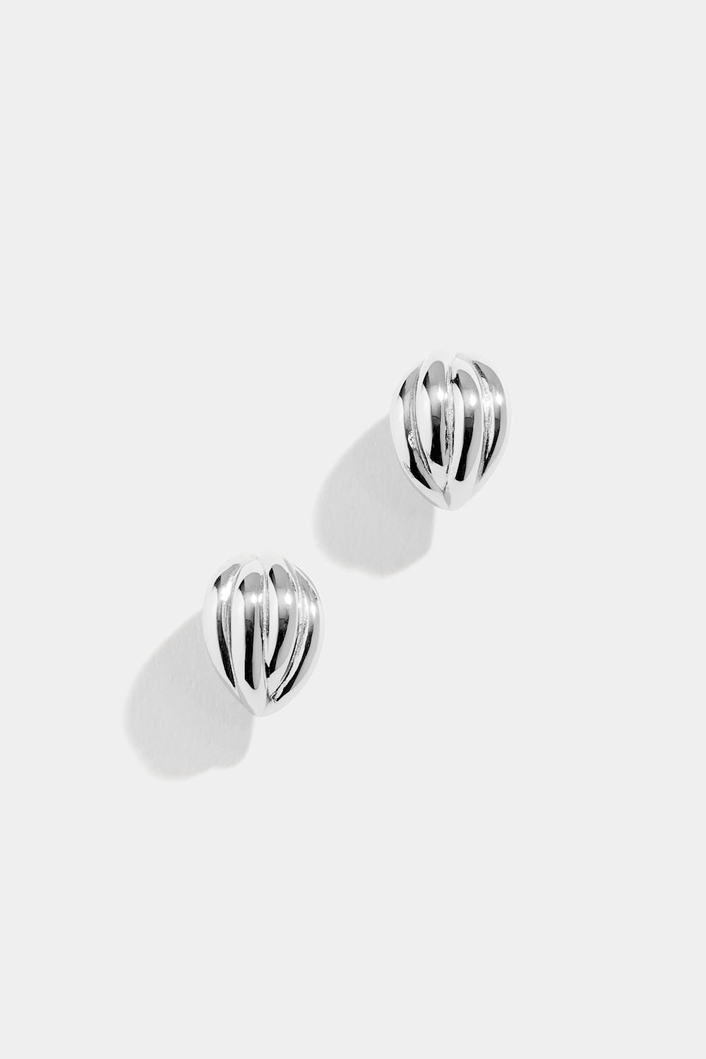 Leveät hopeakorvarenkaat, joissa uurrettu pinta