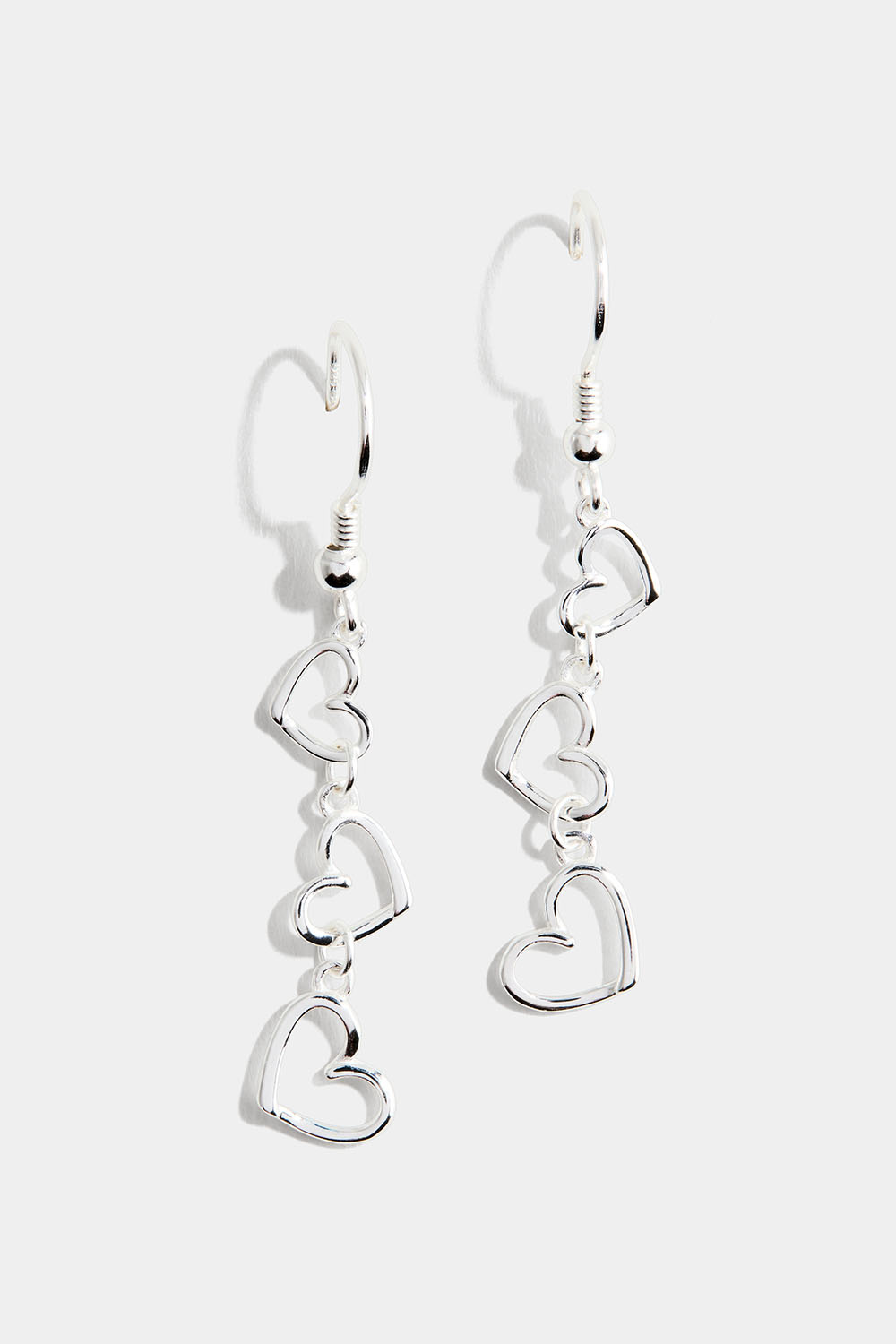 Aidot hopeiset korvakorut, joissa kolme sydäntä