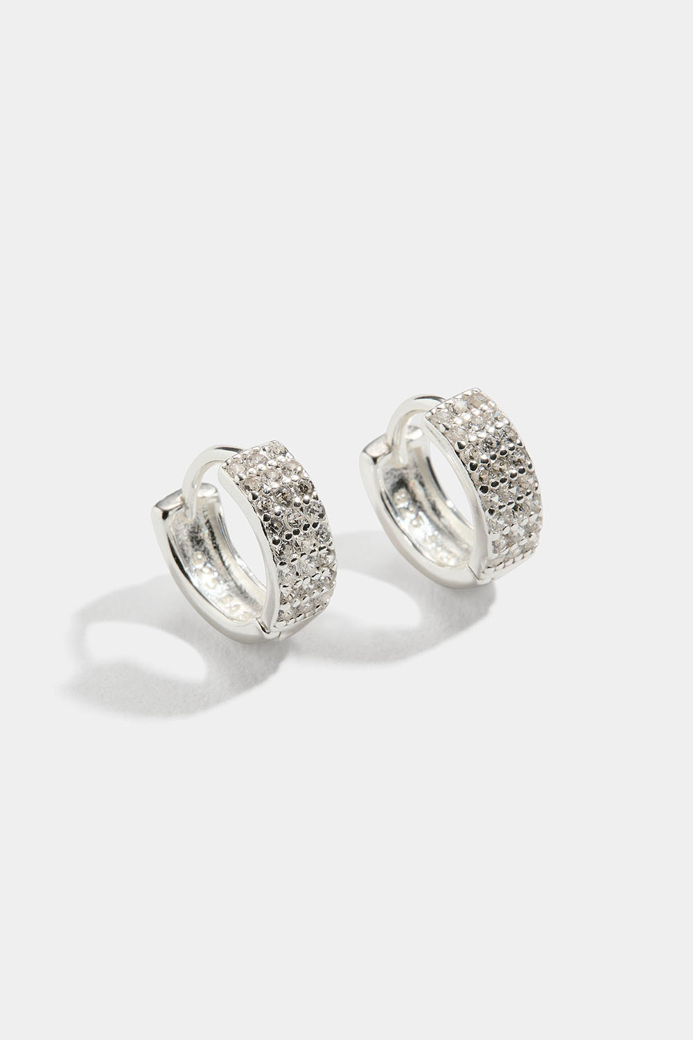 Pienet hopeakorvarenkaat, joissa kolme riviä Cubic zirkonia -kiviä.
