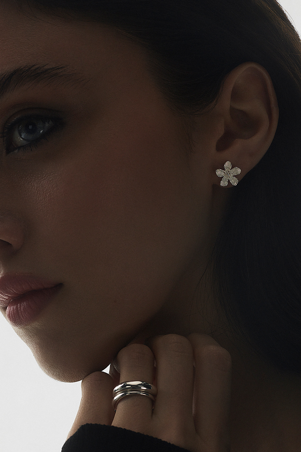 Suuret aidot hopeanappikorvakorut, joissa teksturoituja kukkia